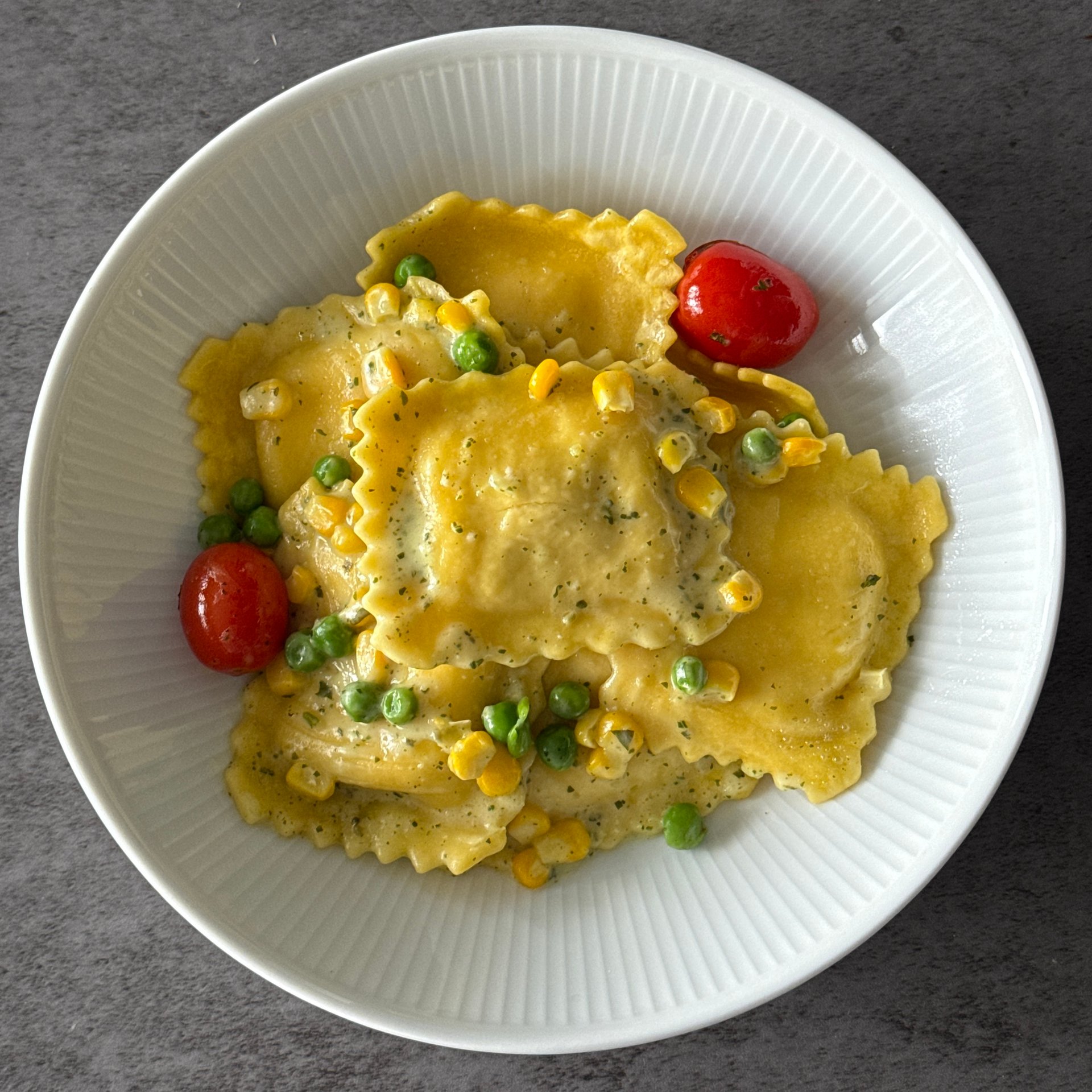 Delicate, handmade ravioli pillows filled with a savory blend of cheeses are coated in a rich, pumpkin seed pesto sauce.