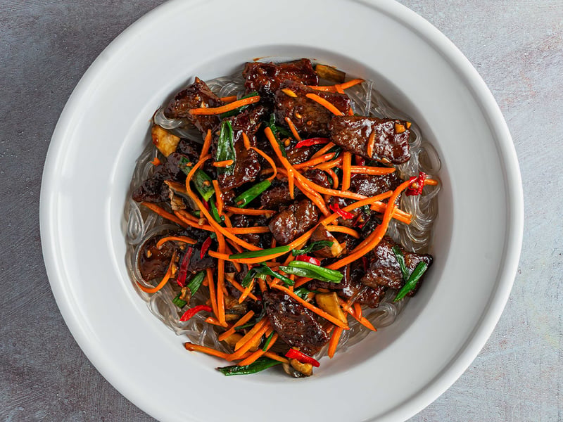 Tender, juicy steak tossed with silky sweet potato glass noodles, earthy crimini mushrooms, crisp shredded carrots, and fresh green scallions.