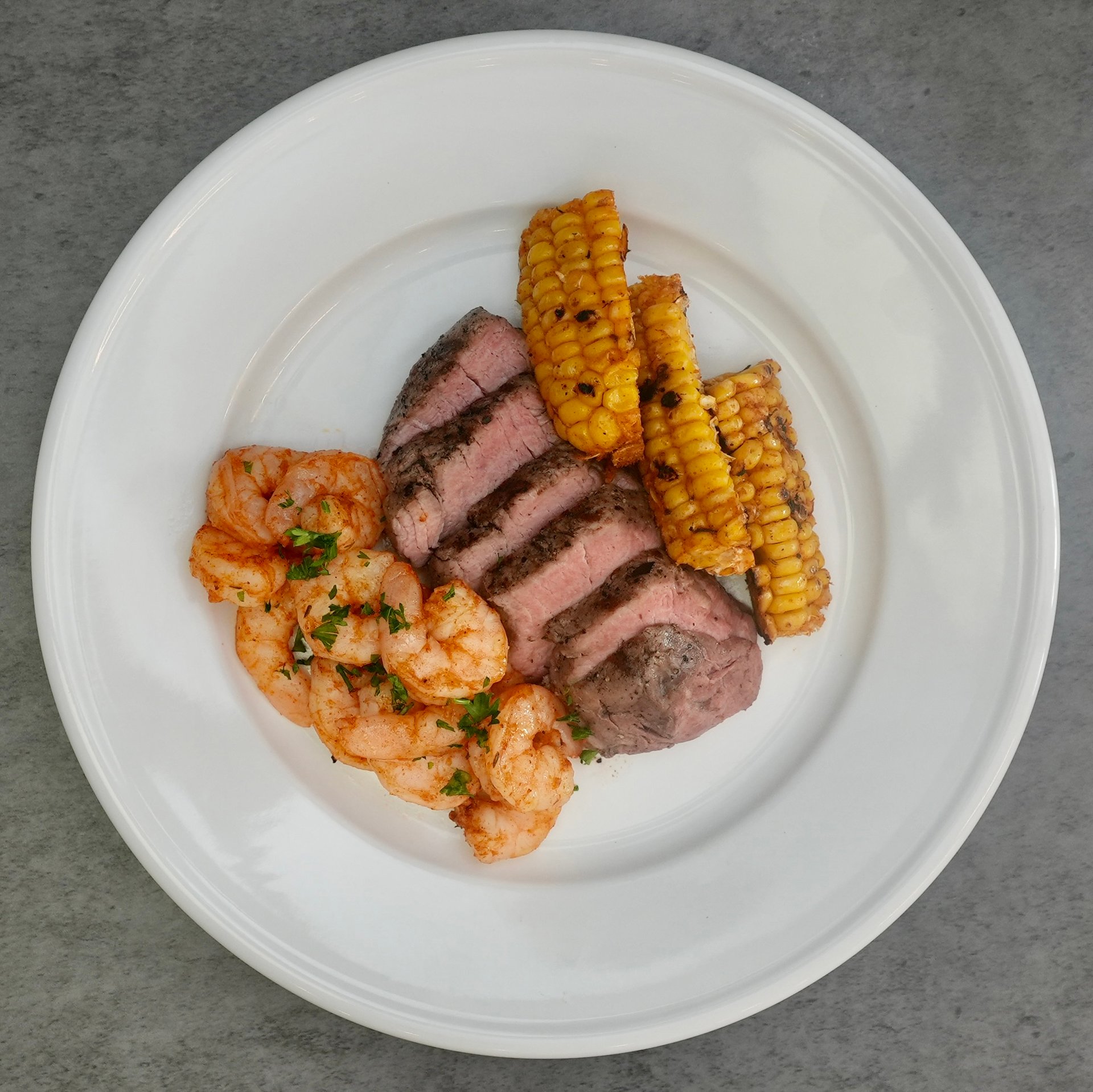 A luxurious pairing of tender, perfectly seasoned filet mignon and bold Cajun-spiced shrimp, served alongside smoky, charred fresh corn ribs.