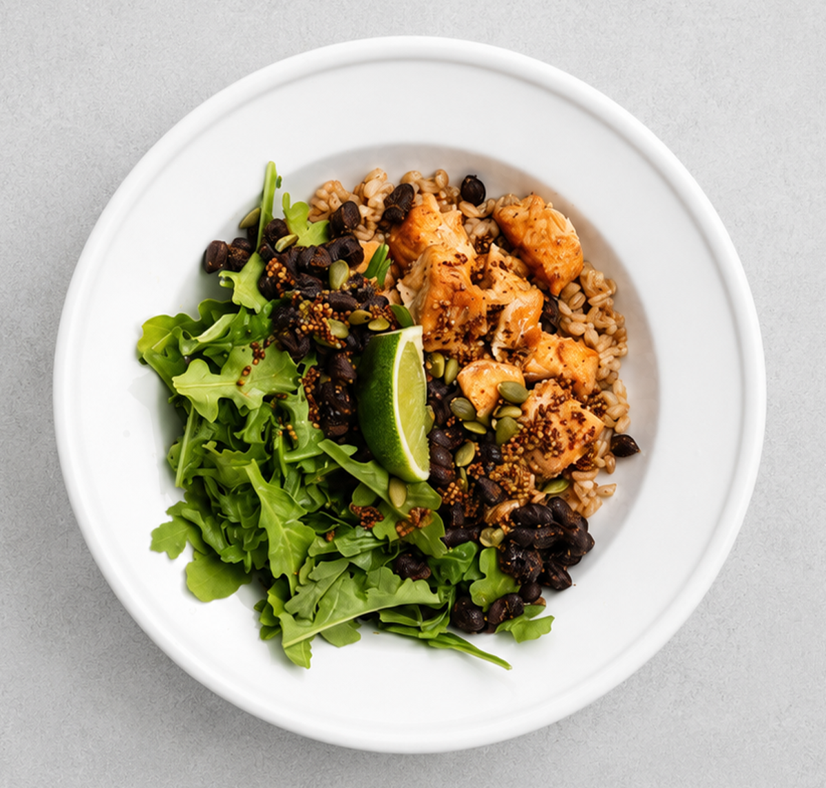 Tender whole-grain farro and seasoned black beans serve as the hearty base for savory salmon bites spiced with cumin, coriander, and chili powder.