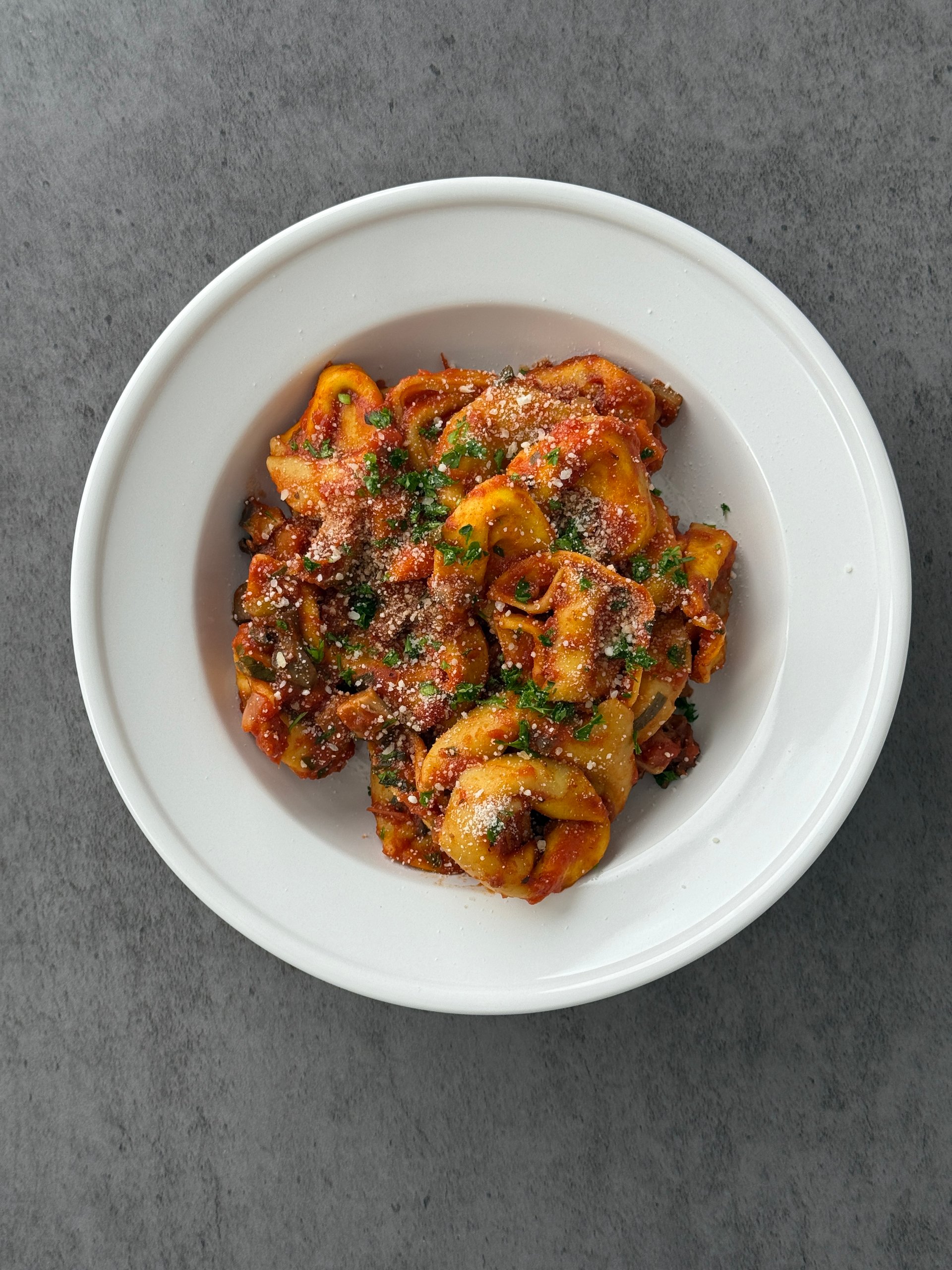 Pillowy handmade ravioli filled with a rich blend of ricotta, mozzarella, fontina, and pecorino, topped with a deeply savory bolognese of slow-simmered portobello, crimini, and shiitake mushrooms in a hearty tomato purée.