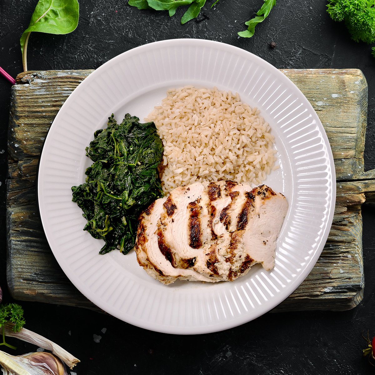 Antibiotic-free chicken breast marinated in a low-sodium herb blend, served with fresh spinach sautéed in olive oil and garlic, alongside perfectly portioned brown rice.