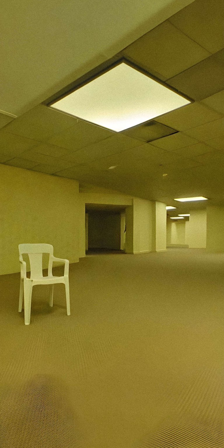 Download this Backrooms 4K wallpaper for your iPhone, showcasing a lone white chair in a corridor with square ceiling lights. This eerie wallpaper captures the unsettling vibe of the Backrooms.