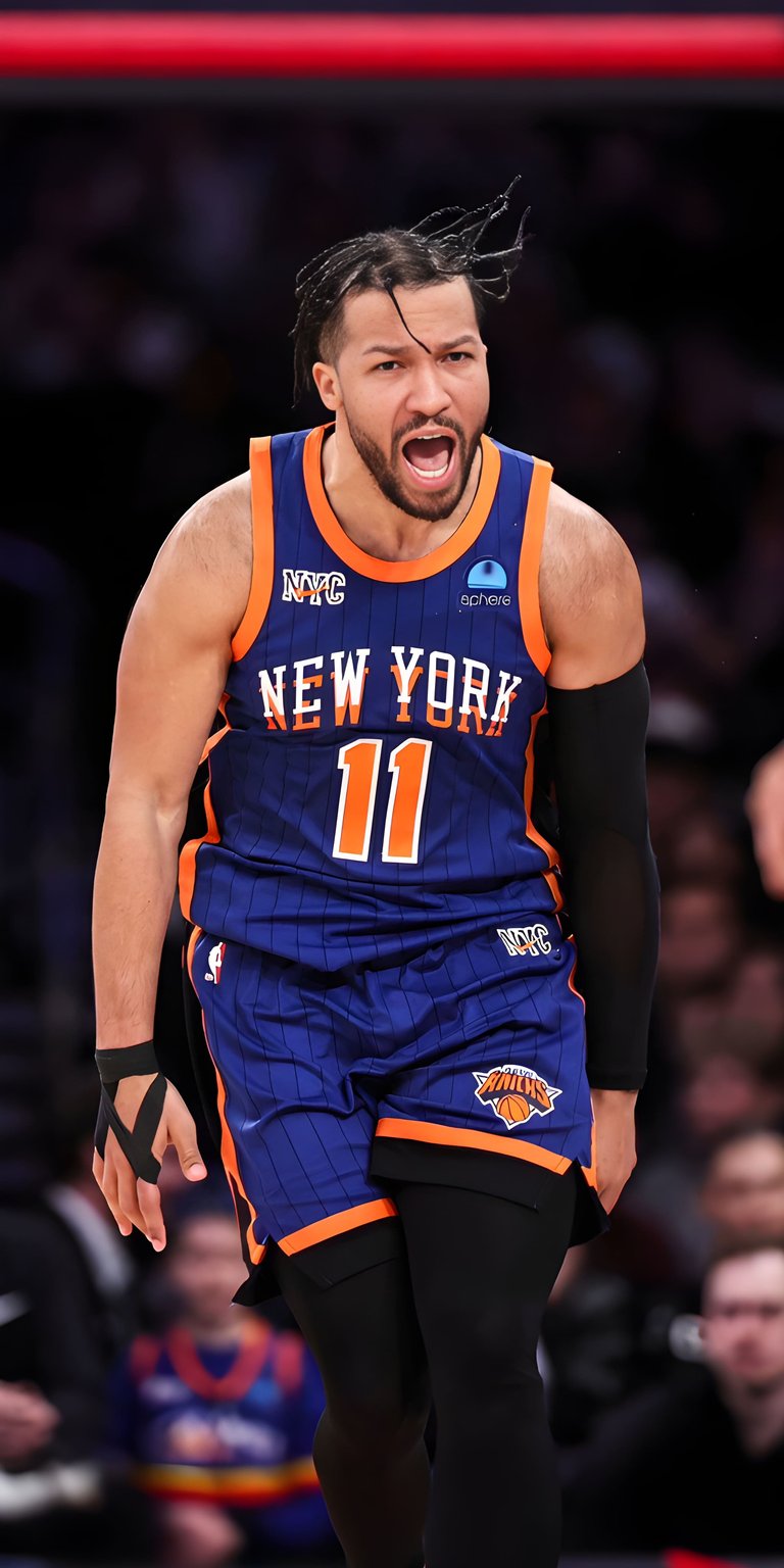 A celebratory and intense shot of Jalen Brunson in the New York Knicks "Statement Edition" blue jersey. Capturing the grit and passion of New York basketball, this wallpaper features the star point guard reacting after a big play at Madison Square Garden.