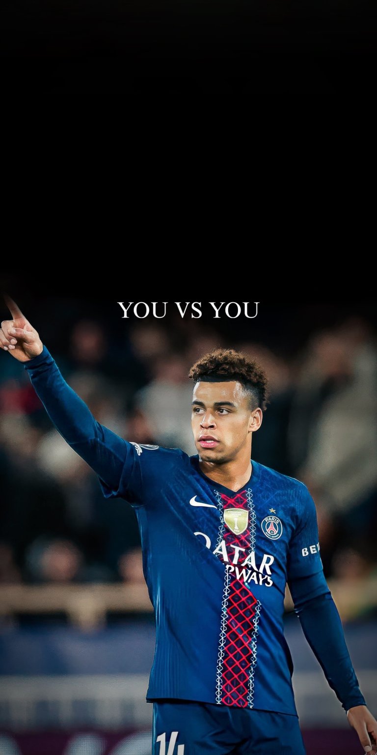 This sports wallpaper features football star Désiré Doué in a PSG kit pointing upward against a dark background. The high-contrast lighting makes it a perfect motivational aesthetic wallpaper for any iPhone.