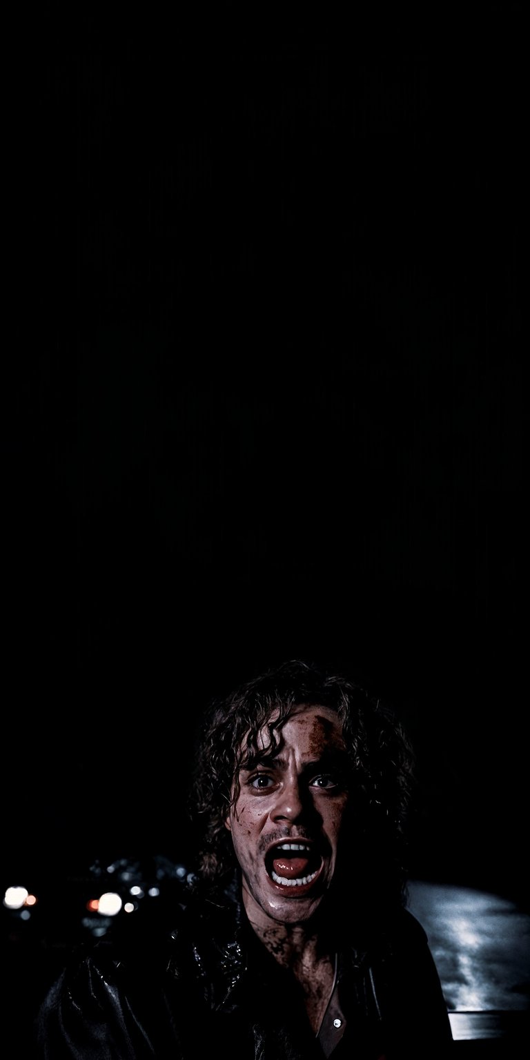 Download this stunning Rory Culkin 4K wallpaper for your iPhone, showcasing the actor's intense expression and smeared makeup. This high-resolution wallpaper captures the raw emotion of Rory with his wide-open mouth and wild curly hair.