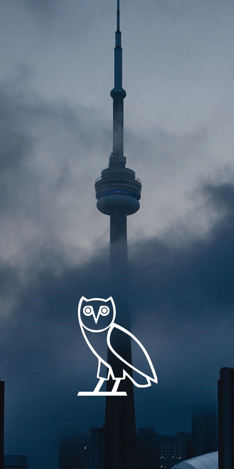 Elevate your iPhone screen with this striking Drake wallpaper in 4K. It features Toronto's CN Tower shrouded in mist, a large digital clock, and Drake's signature owl logo.