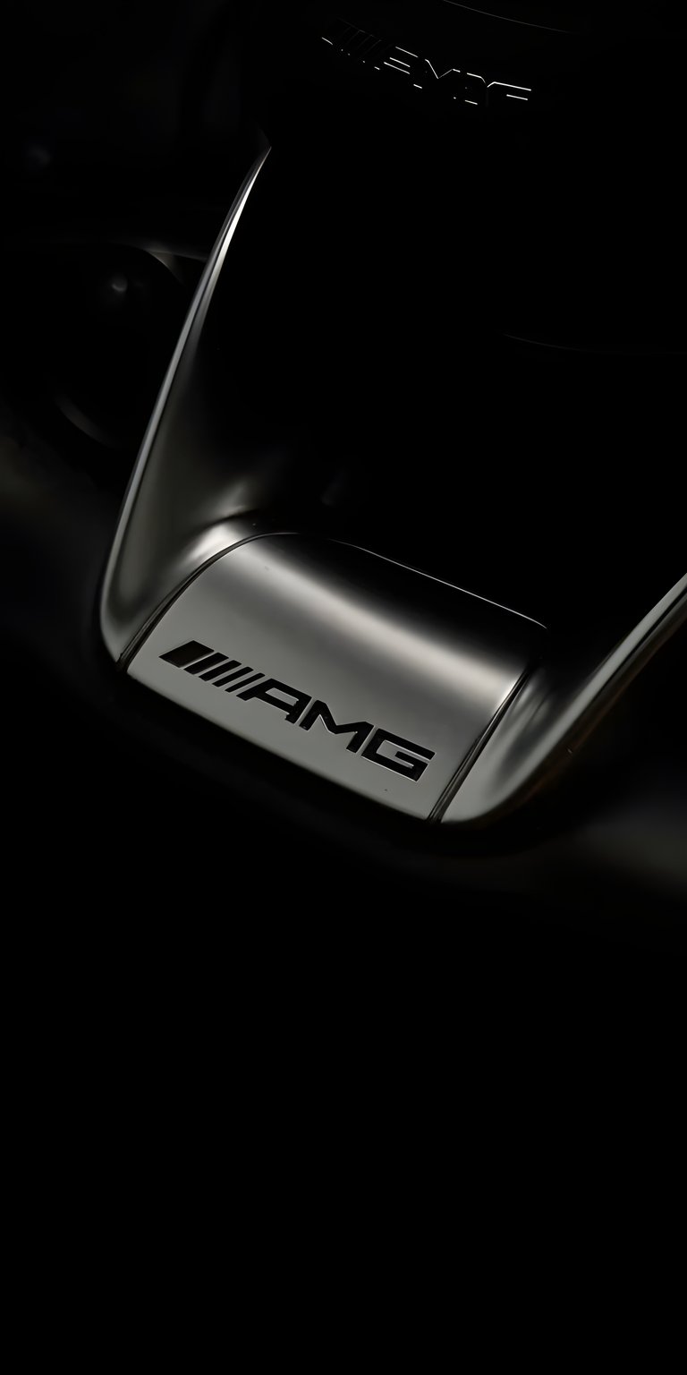 A sophisticated, high-detail live wallpaper featuring an extreme close-up of a sleek, reflective AMG badge (Mercedes-Benz's performance division) set against a dark, metallic surface, likely the bodywork of a high-performance vehicle. The focus is entirely on the metallic texture and the embossed logo. The animation emphasizes the subtle, shifting reflections of ambient light across the polished chrome and the deep black paint, highlighting the luxury and engineering quality of the brand.