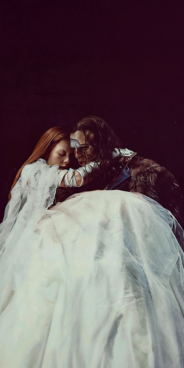 A dramatic and intimate moment featuring Elizabeth (Mia Goth) and the Creature (Jacob Elordi) from Guillermo del Toro's Frankenstein (2025). The image captures a complex blend of tenderness and gothic intensity, highlighted by the contrast of the ethereal white gown and the Creature's bandages. Perfect for fans of the film who appreciate its deep themes of connection, isolation, and tragic romance.