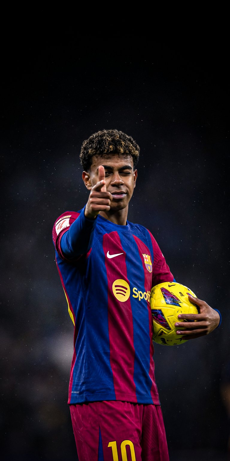 Celebrate the rising talent with this 4K wallpaper showing Lamine Yamal pointing forward in his official FC Barcelona home kit. This vibrant iPhone wallpaper highlights the detailed texture of the jersey and the athlete's confident expression in a professional studio style.