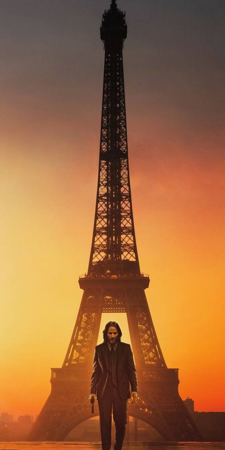 John Wick standing behind is the Eiffel Tower in a sunset color view wallpaper 4k