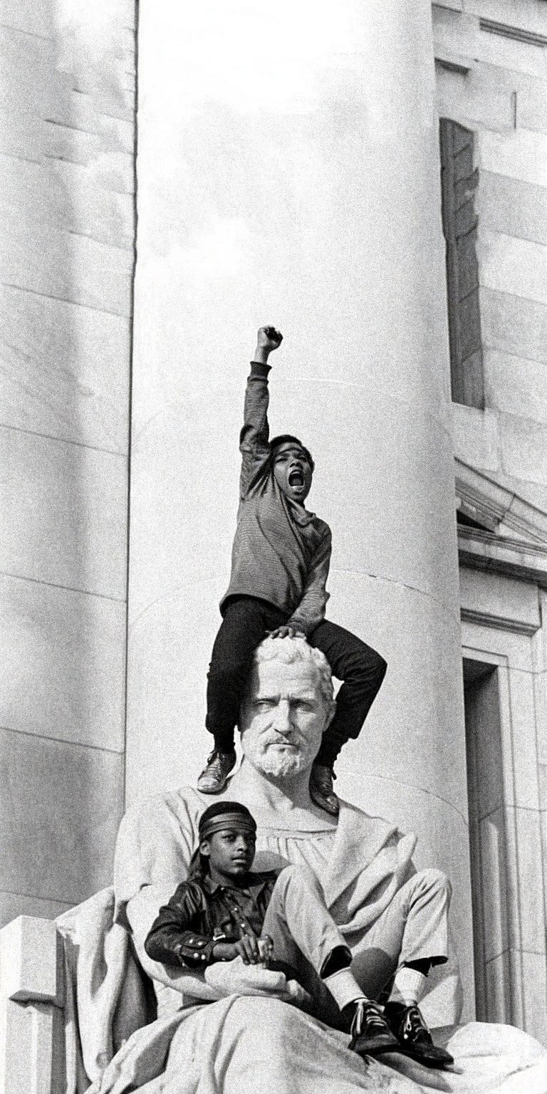 This powerful aesthetic wallpaper features a protester sitting atop a stone statue in a moment of defiance. It creates a bold and inspiring look for your iPhone lock screen.