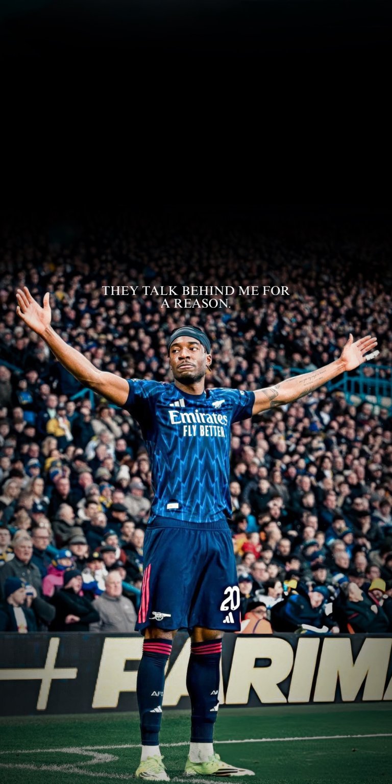 This 4K OLED wallpapers design features Noni Madueke in an Arsenal kit for your iPhone. The wallpaper showcases a deep black background contrasted with a vibrant blue jersey and high-intensity stadium lighting.