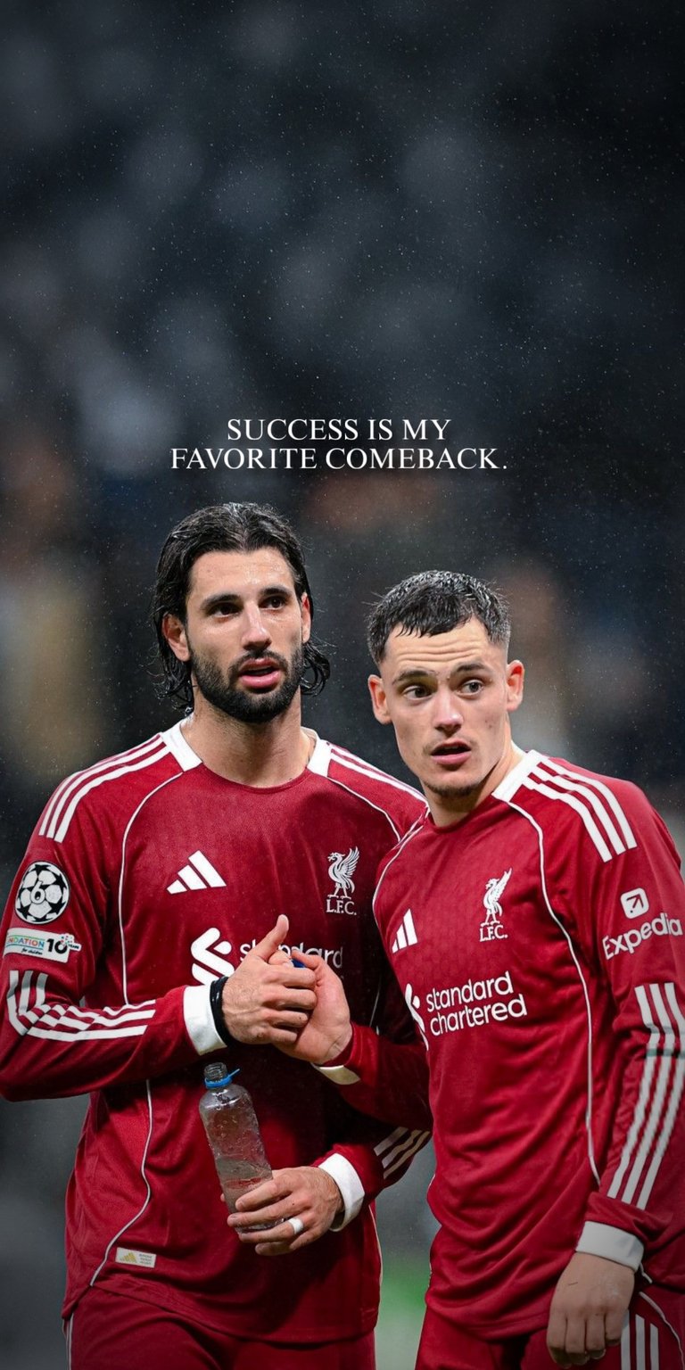 A high-quality motivational wallpaper featuring two prominent Liverpool FC players, possibly during a Champions League match. The athletes are shown in their iconic red kits, sharing a focused, intense moment, embodying teamwork and determination. The top of the wallpaper features the empowering quote, "SUCCESS IS MY FAVORITE COMEBACK," making it an ideal screen background for football fans and anyone seeking daily motivation and inspiration.