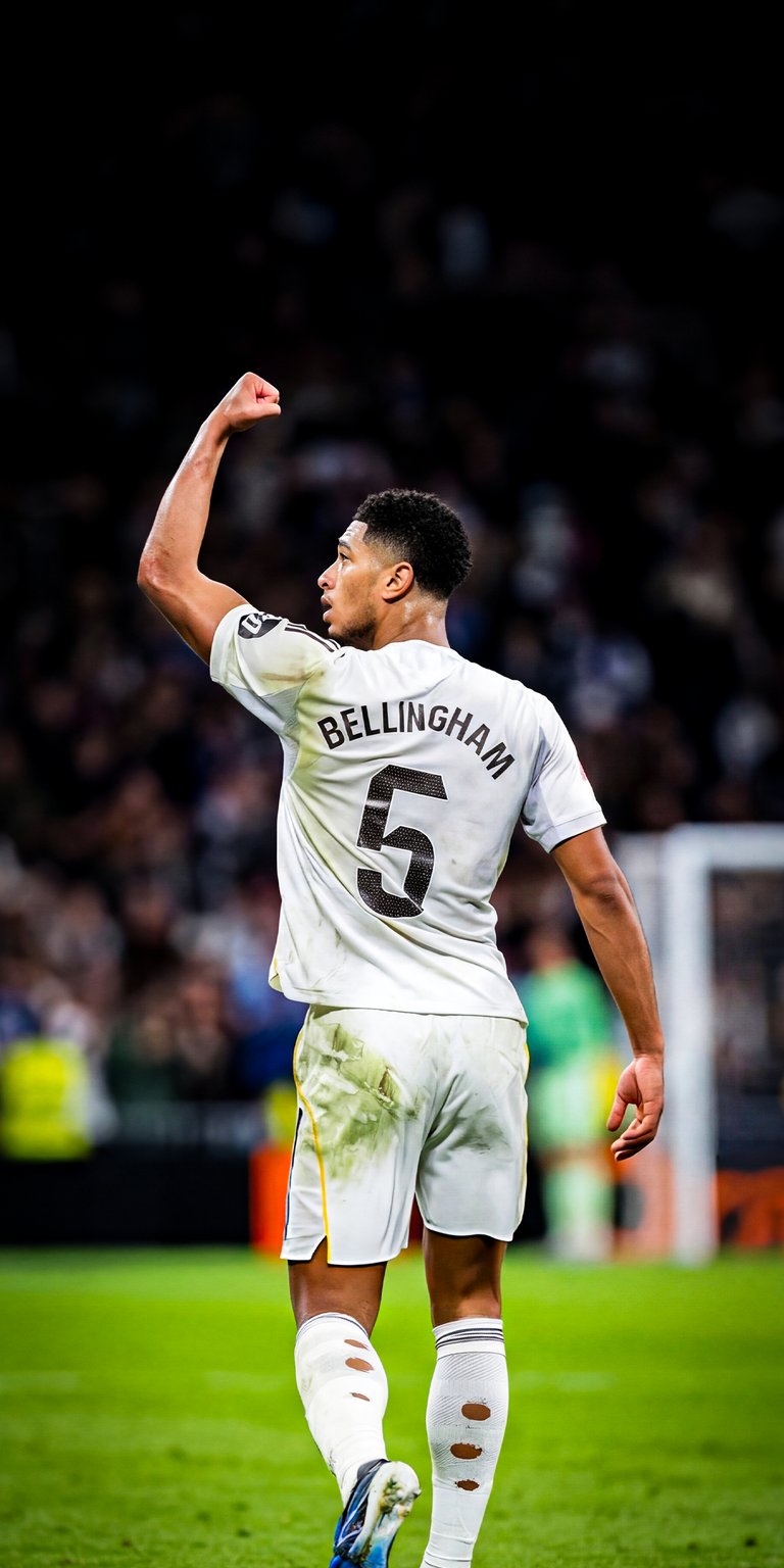 Celebrate the brilliance of Jude Bellingham with this 4K wallpaper capturing his iconic arms-wide celebration in the Real Madrid white kit. Show your passion on your iPhone with this high-resolution football wallpaper featuring the world-class midfielder in action.