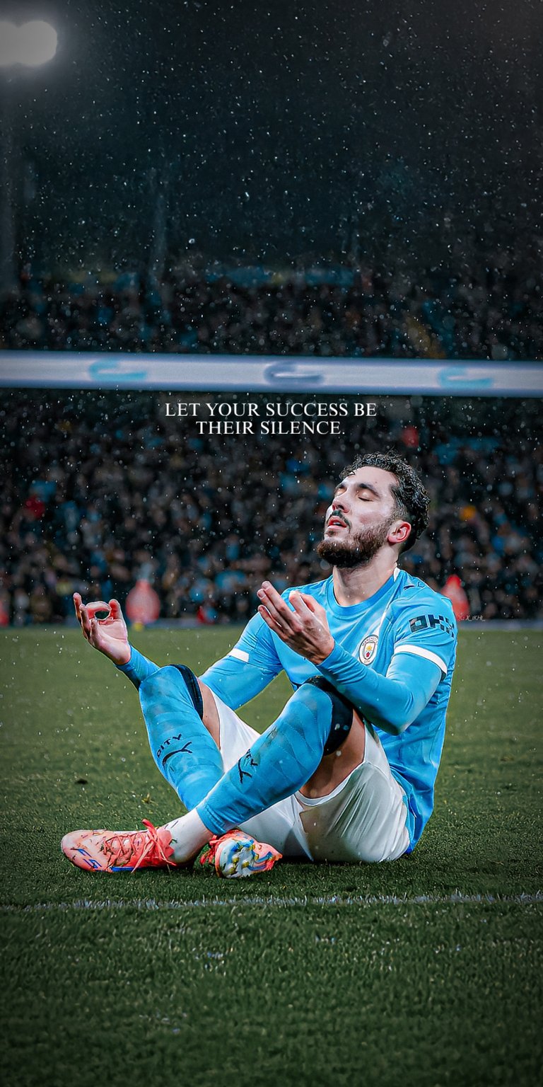 This wallpaper features the talented Olympique Lyonnais playmaker Rayan Cherki in his iconic "Zen" meditation celebration pose on the pitch. Dressed in a vibrant blue kit, the image captures Cherki’s calm and confident demeanor during a match. The design is enhanced with the powerful motivational quote: "LET YOUR SUCCESS BE THEIR SILENCE," making it a perfect background for football fans who value focus and proving the doubters wrong.