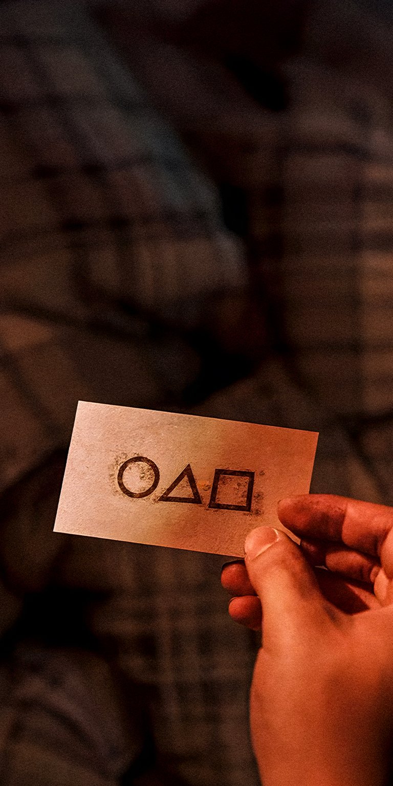 Hand holding a Squid game calling card front logo wallpaper