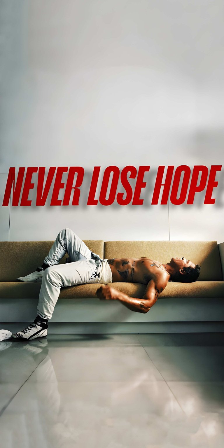 Download this Anthony Joshua wallpaper in stunning 4K resolution for your iPhone! The wallpaper shows Joshua reclining on a couch under the words "Never Lose Hope", wearing athletic pants and high-top sneakers.
