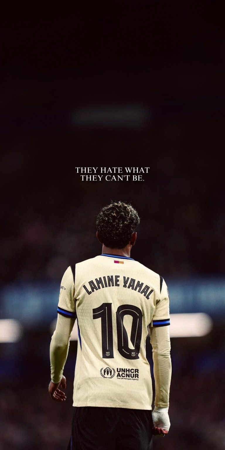A dramatic rear shot of FC Barcelona and Spain wonderkid Lamine Yamal, showcasing him in the iconic number 10 jersey. This image features the defiant quote: "They hate what they can't be". The jersey also features the logo for UNHCR/ACNUR, the UN Refugee Agency, a partner of the club. Ideal for football enthusiasts and adding a fierce, competitive edge to your screen.