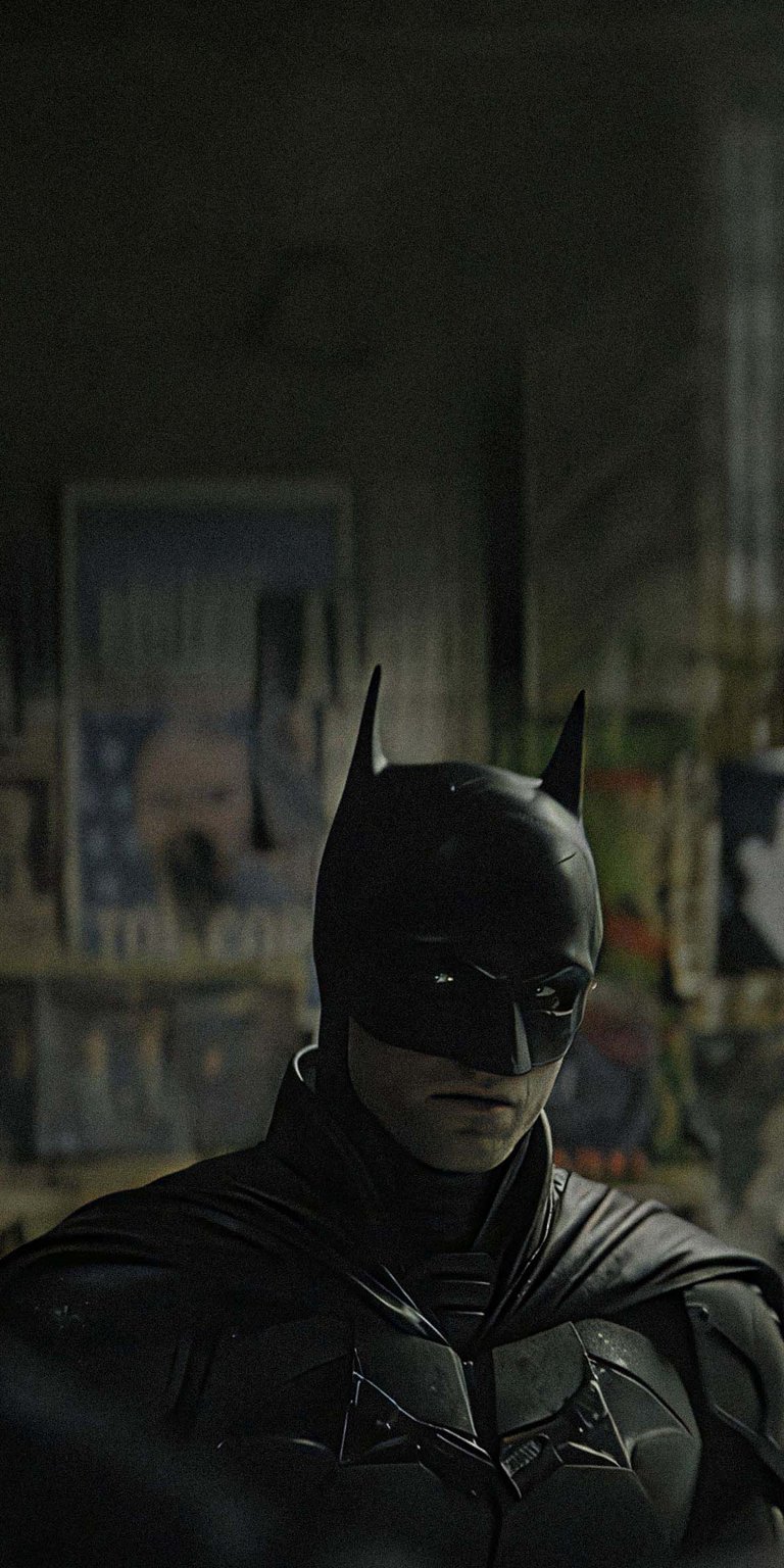 Download this striking Batman 4K wallpaper for your iPhone, featuring a close-up of his armored suit. The background reveals graffiti-covered walls and blurred posters, adding gritty detail to this stunning wallpaper.