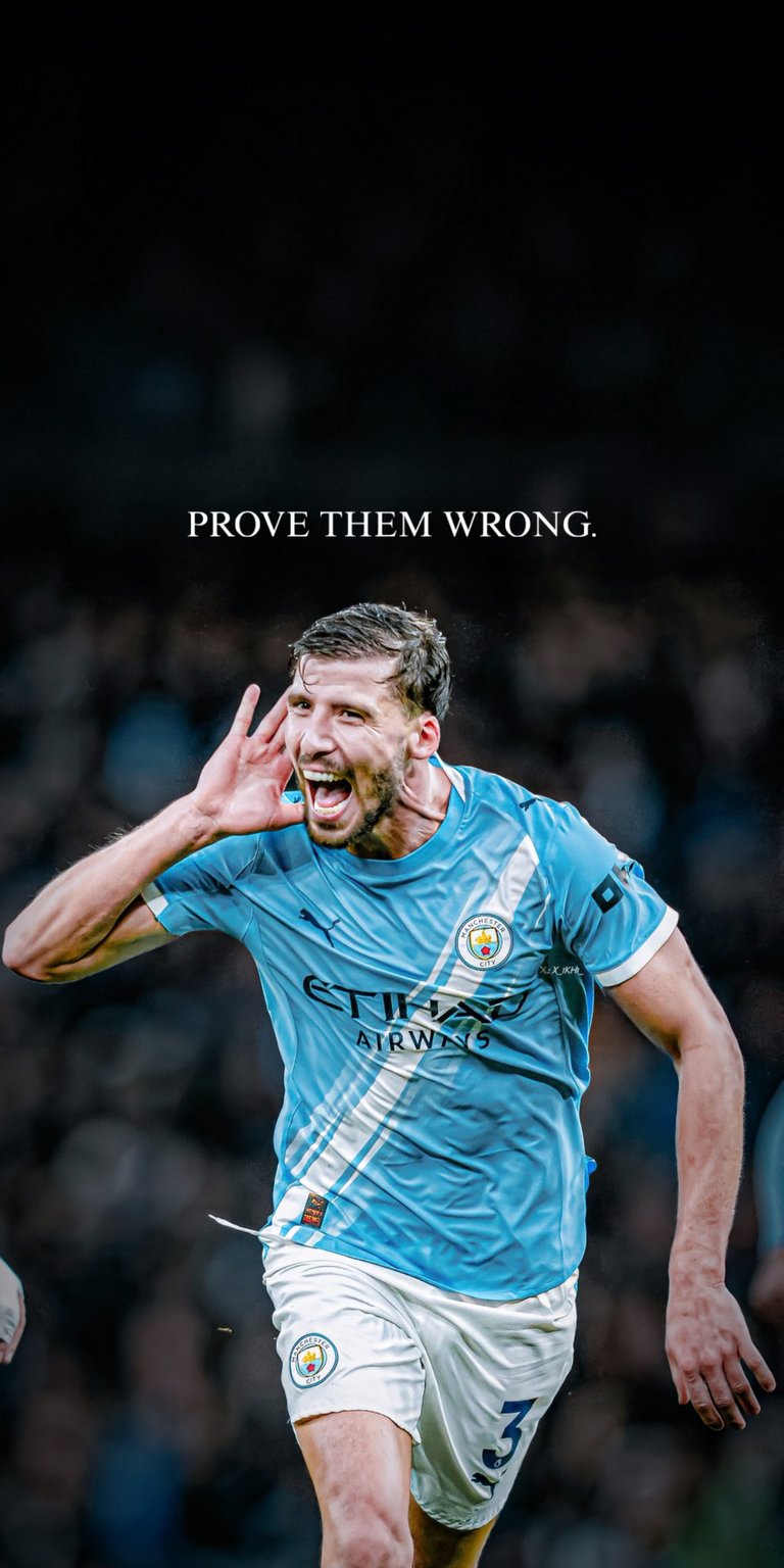 Show your support for Manchester City's formidable defender, Rúben Dias, with this focused live wallpaper. The image captures Dias celebrating with an intense expression, accompanied by the powerful, challenging quote, "PROVE THEM WRONG." The Manchester City blue kit and the dramatic lighting create a strong, champion aesthetic. Perfect for City fans and those who admire fierce determination in sports.