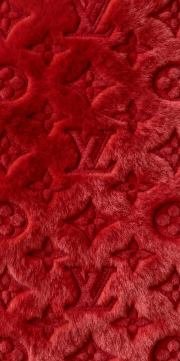 Elevate your iPhone with this stunning Louis Vuitton 4K wallpaper. The red furry texture wallpaper features classic LV logos, floral emblems, and subtle shadowing.