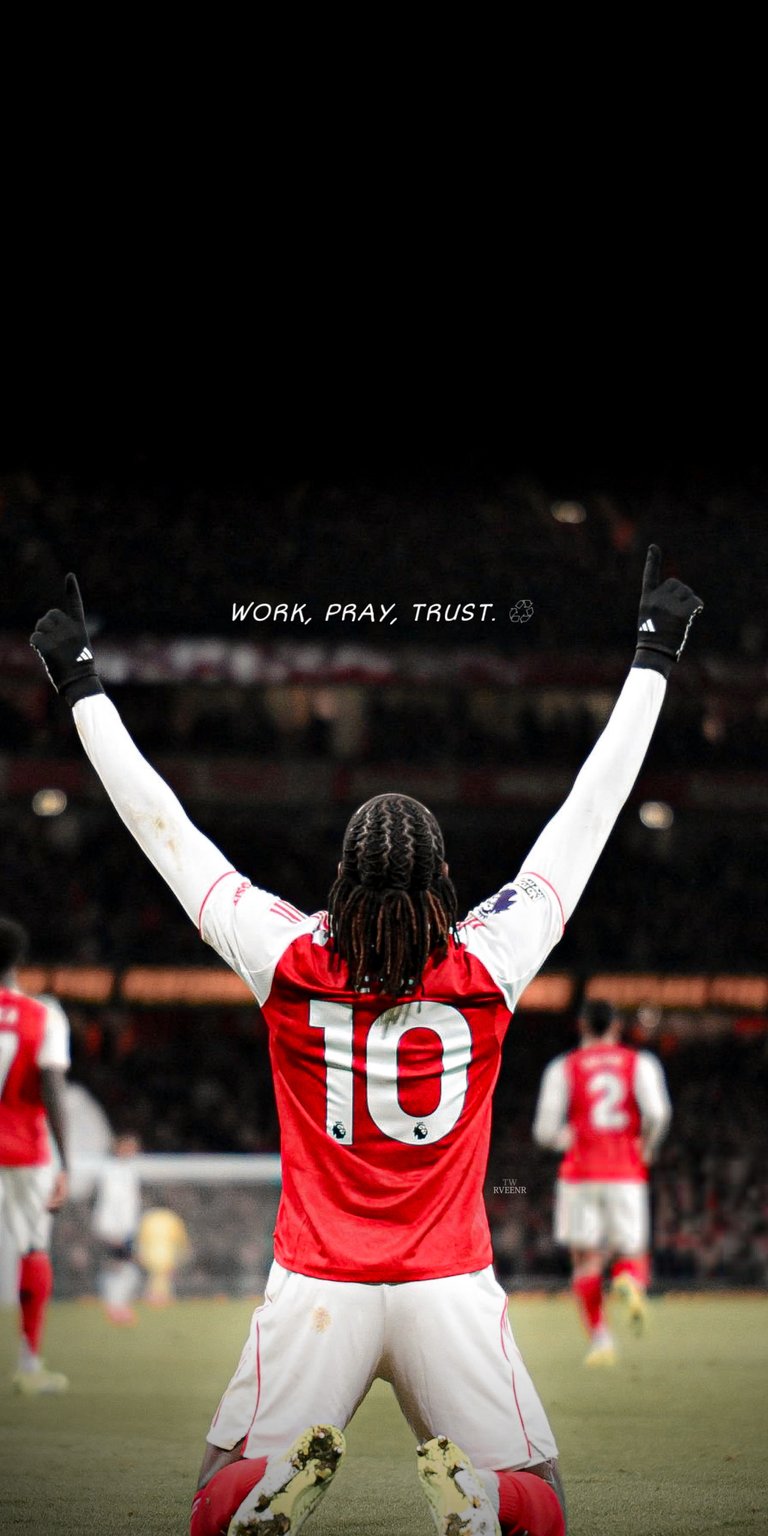 A powerful, atmospheric shot of Arsenal's number 10, Eberechi Eze, in a celebratory pose, featuring the motivational quote: "Work, Pray, Trust". This image captures the determined spirit of the English professional footballer, who recently scored a hat-trick in the North London Derby against Tottenham. Perfect for football fans, athletes, and anyone seeking daily inspiration to pursue their goals.