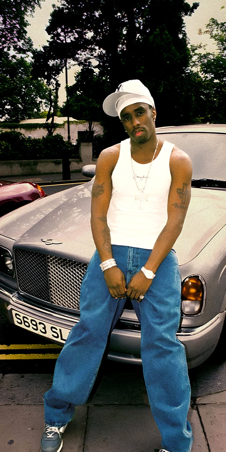 Diddy wearing sleeveless top leaning on the car hood wallpaper