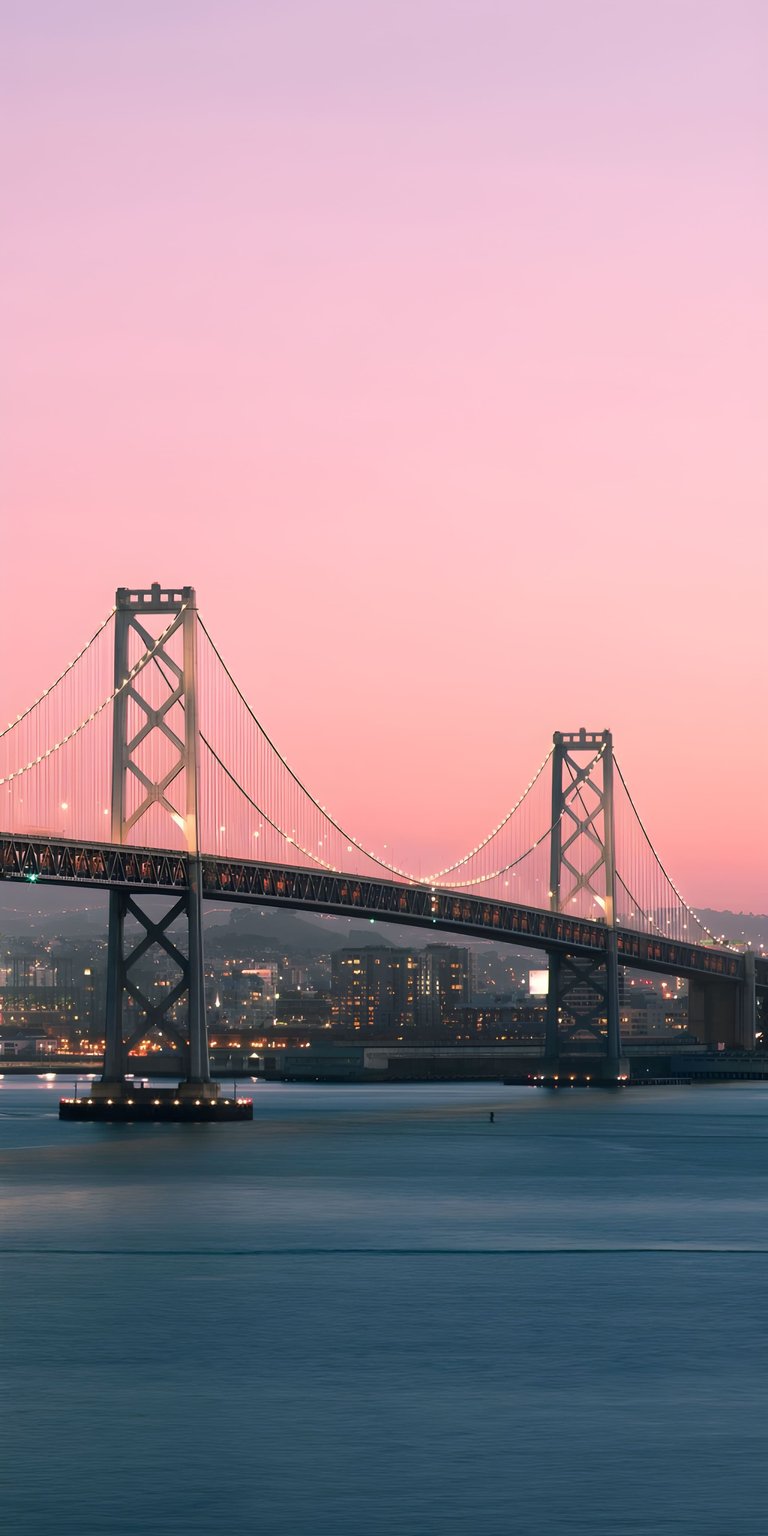 Download this stunning 4K wallpaper of the San Francisco Oakland Bay Bridge during a serene pink sunset. This high-resolution 4K wallpaper brings a professional cityscape aesthetic to any iPhone or Android device.
