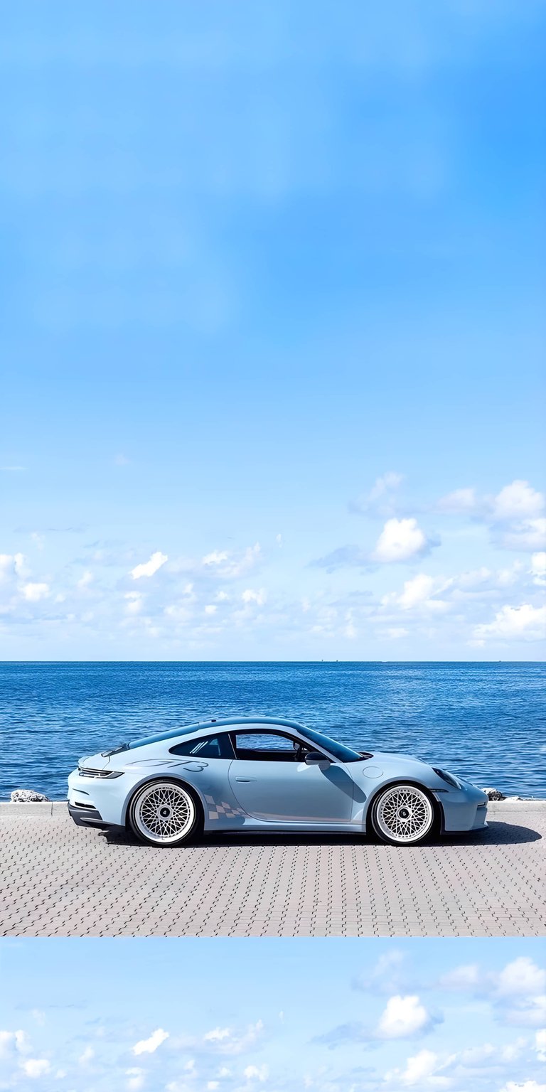 Upgrade your iPhone with this serene 4K wallpaper showing a light blue Porsche parked by the bright blue ocean. This vibrant wallpaper captures the perfect summer aesthetic with clear skies and coastal scenery for your mobile background.