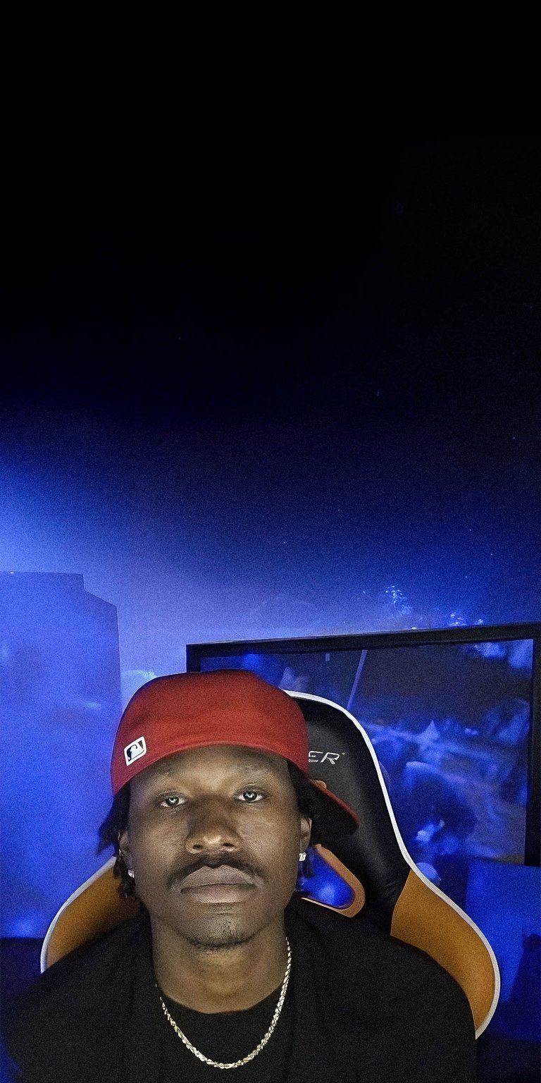 Duke Dennis wearing a cap in his gaming chair wallpaper