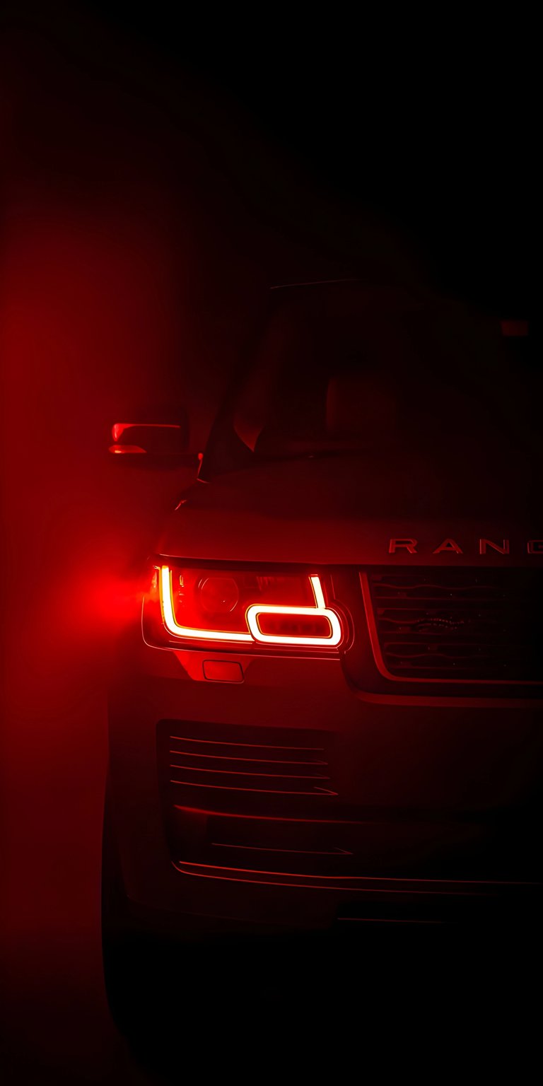 Enhance your iPhone with this premium Range Rover 4K OLED wallpaper featuring a glowing red signature headlight. This wallpaper utilizes deep blacks and moody crimson lighting to create a sophisticated, high-contrast look for your device.
