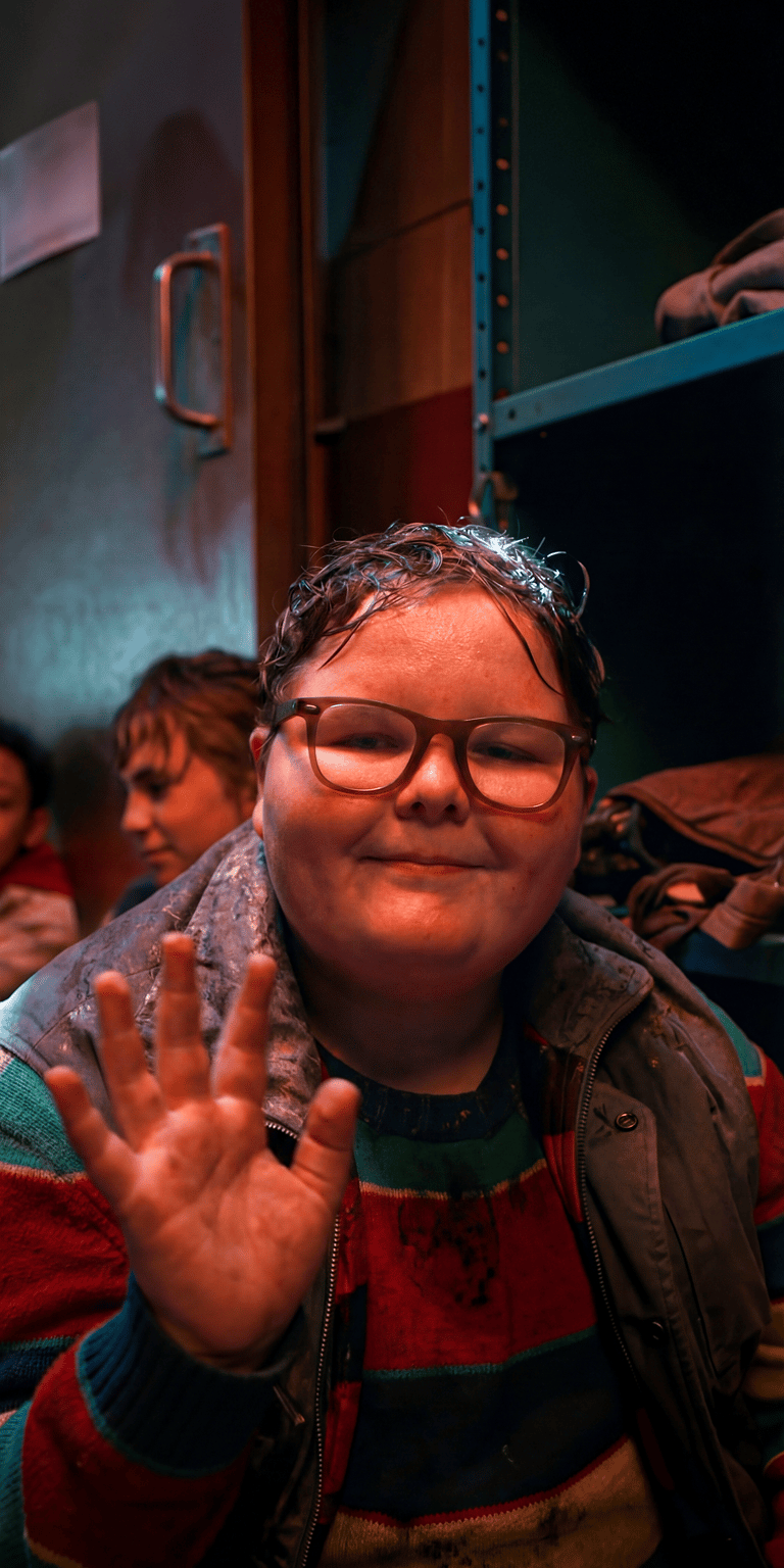 A portrait of Derek Turnbow in his "Delightful Derek" era. This wallpaper showcases the character's unique 1980s look, featuring his multi-colored striped shirt and oversized glasses, representing his journey from school bully to an unlikely hero of the Party.