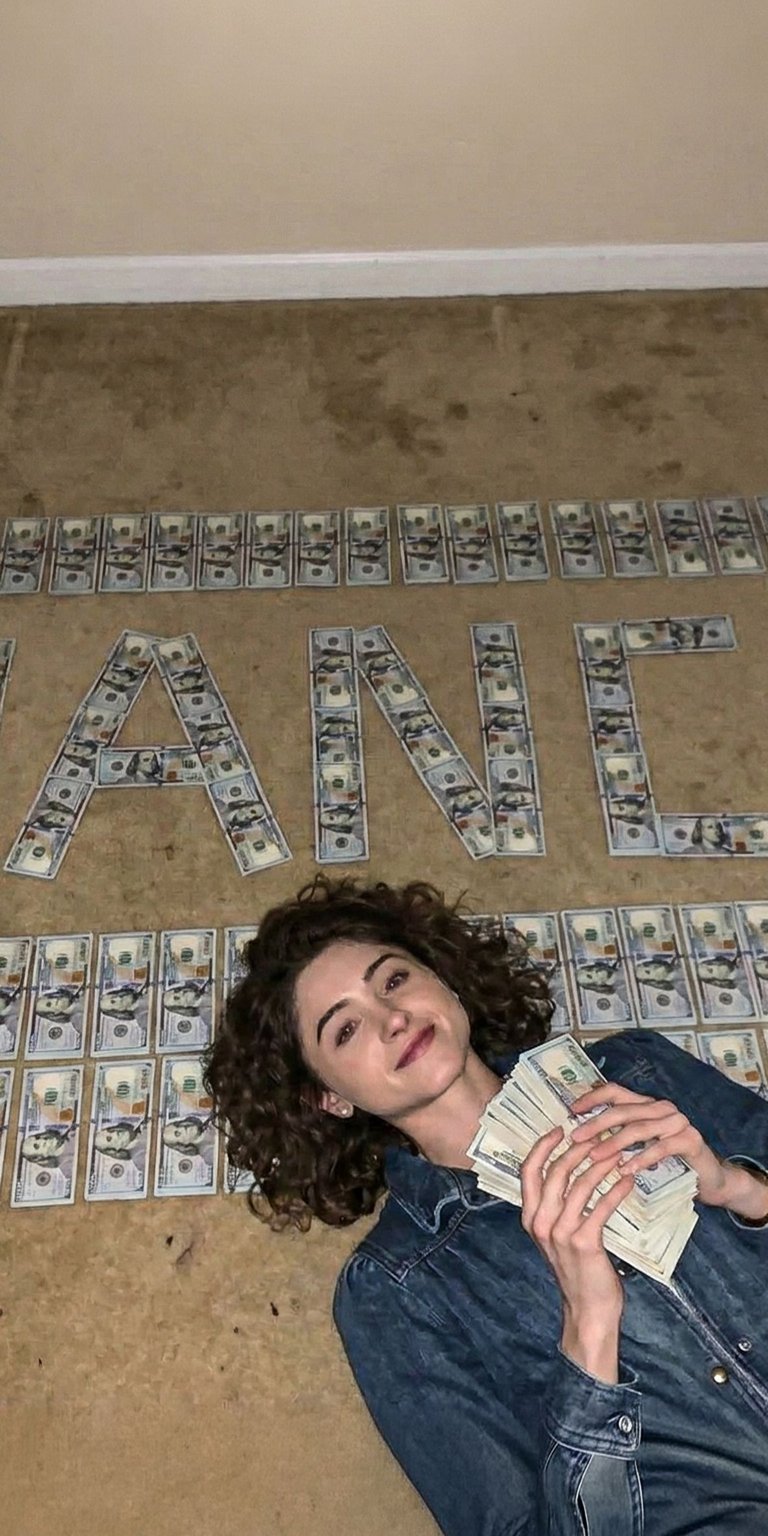 This live wallpaper features Nancy Wheeler, the dedicated investigative heroine of Stranger Things. She is lying on the floor, surrounded by dollar bills that clearly spell out her name, "NANCY". She is dressed in a practical denim shirt and jeans, reflecting her active, determined role, and holds a fan of money. This wallpaper celebrates the strength and focus of one of the show's main protagonists.
