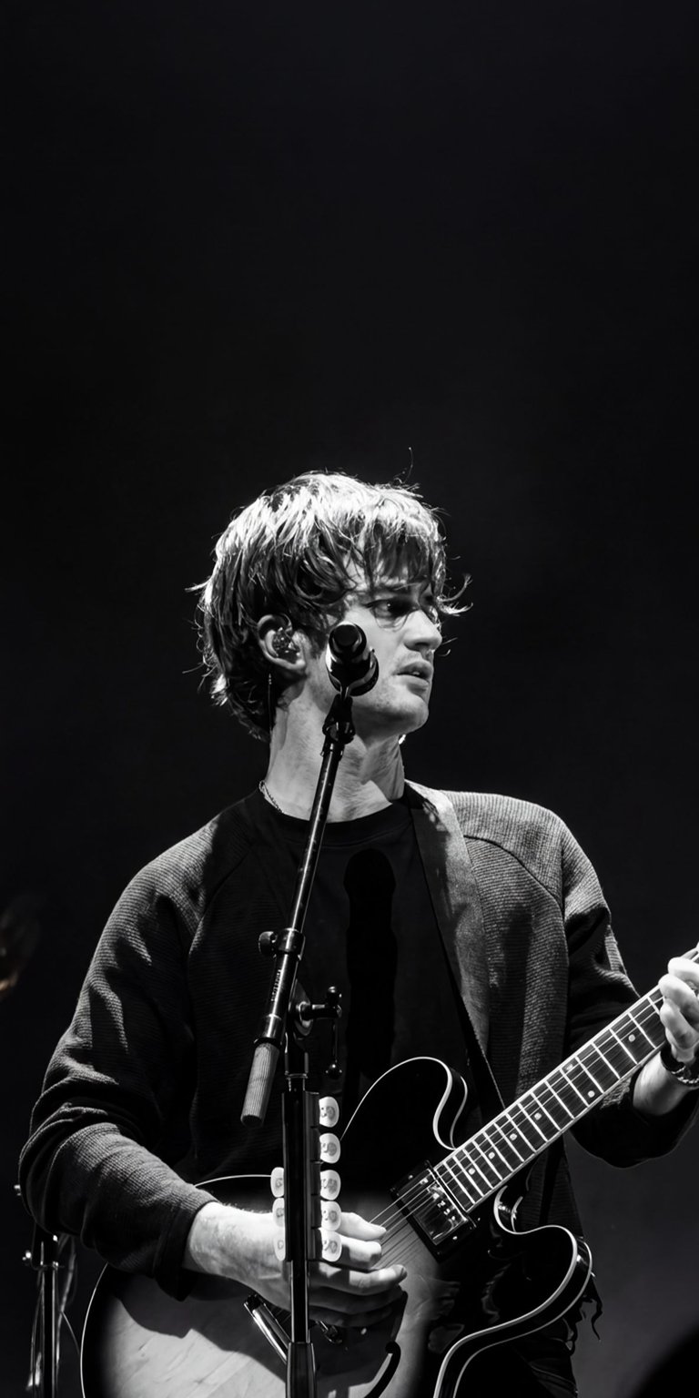 Get this striking Oscar Lang 4K wallpaper for your iPhone, showcasing the musician in black and white. This wallpaper highlights Oscar with his signature haircut, a fitted earpiece, and sleek guitar.