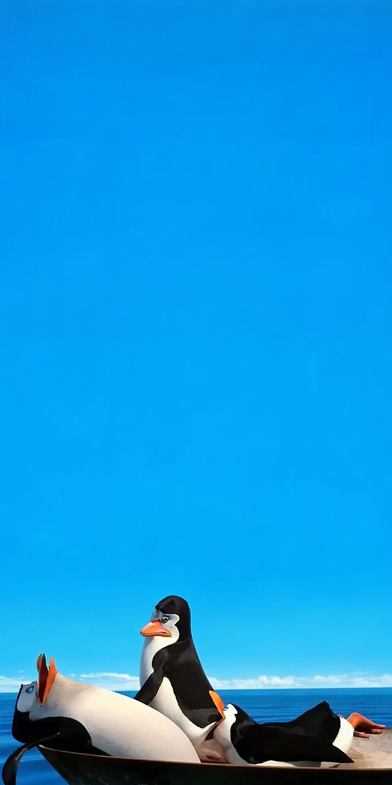 Enjoy this 4K wallpaper featuring the Penguins of Madagascar on an iPhone! The background is a beautiful blue sky, with the penguins seated in a boat, and the iPhone screen displays the time.