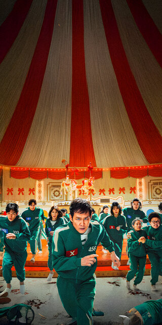 Seong Gihun player 456 running with other players in a Mingle game wallpaper