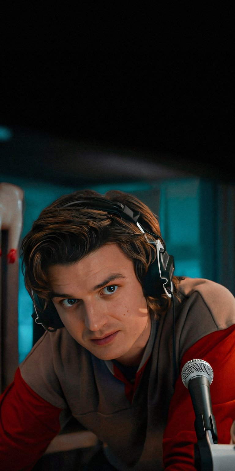 Get this cool Steve Harrington 4K wallpaper for your iPhone! This wallpaper features Steve in headphones, with a microphone, and red sleeves.