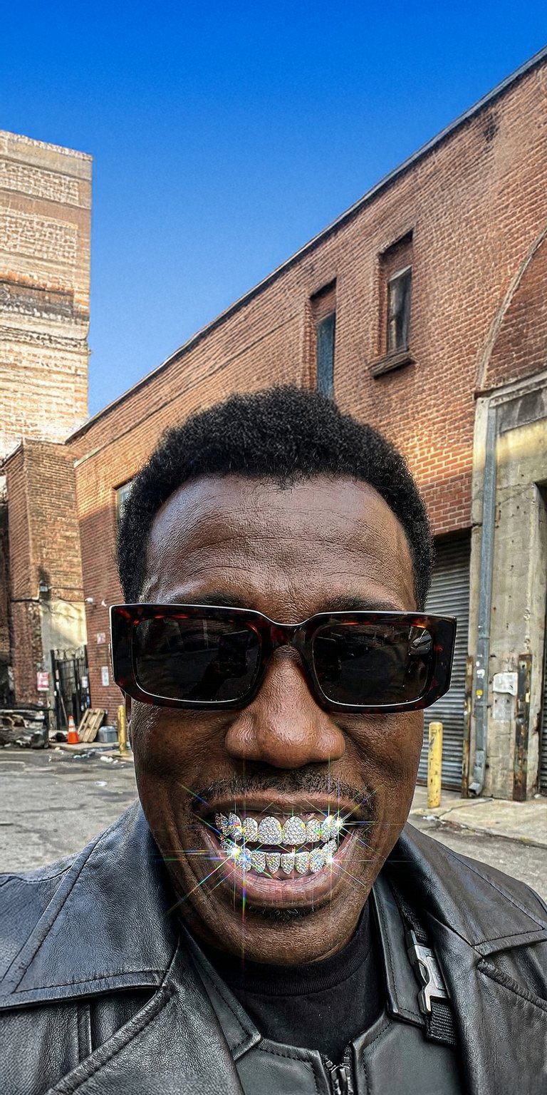 This 4K aesthetic wallpaper features a realistic Steve Harvey wearing iced-out diamond grillz while posing in an urban alley. Elevate your iPhone with this wallpaper showcasing sharp textures, a black leather jacket, and brilliant jewelry glints under a clear blue sky.