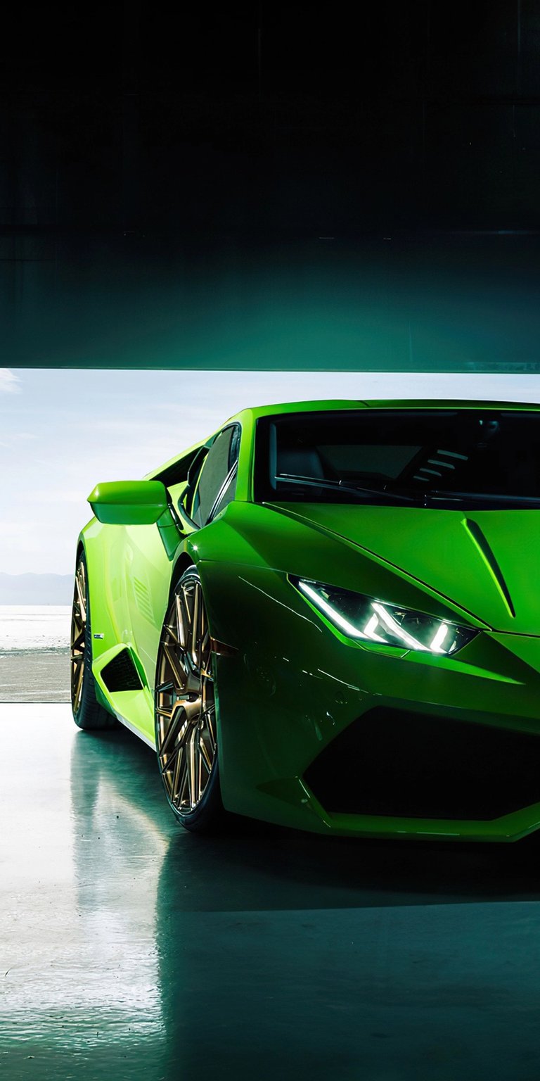 Grab this stunning Lamborghini wallpaper in 4K for your iPhone, showcasing its sleek green design. Notice the gold rims and the way the headlights illuminate the glossy floor.