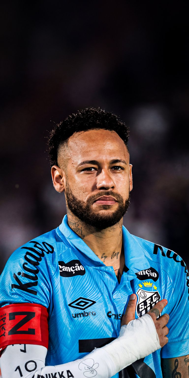 Get this stunning Neymar 4K wallpaper for your iPhone, showcasing the star player in his Santos jersey. This wallpaper captures Neymar's focused gaze and the details of his arm band and neck tattoos.