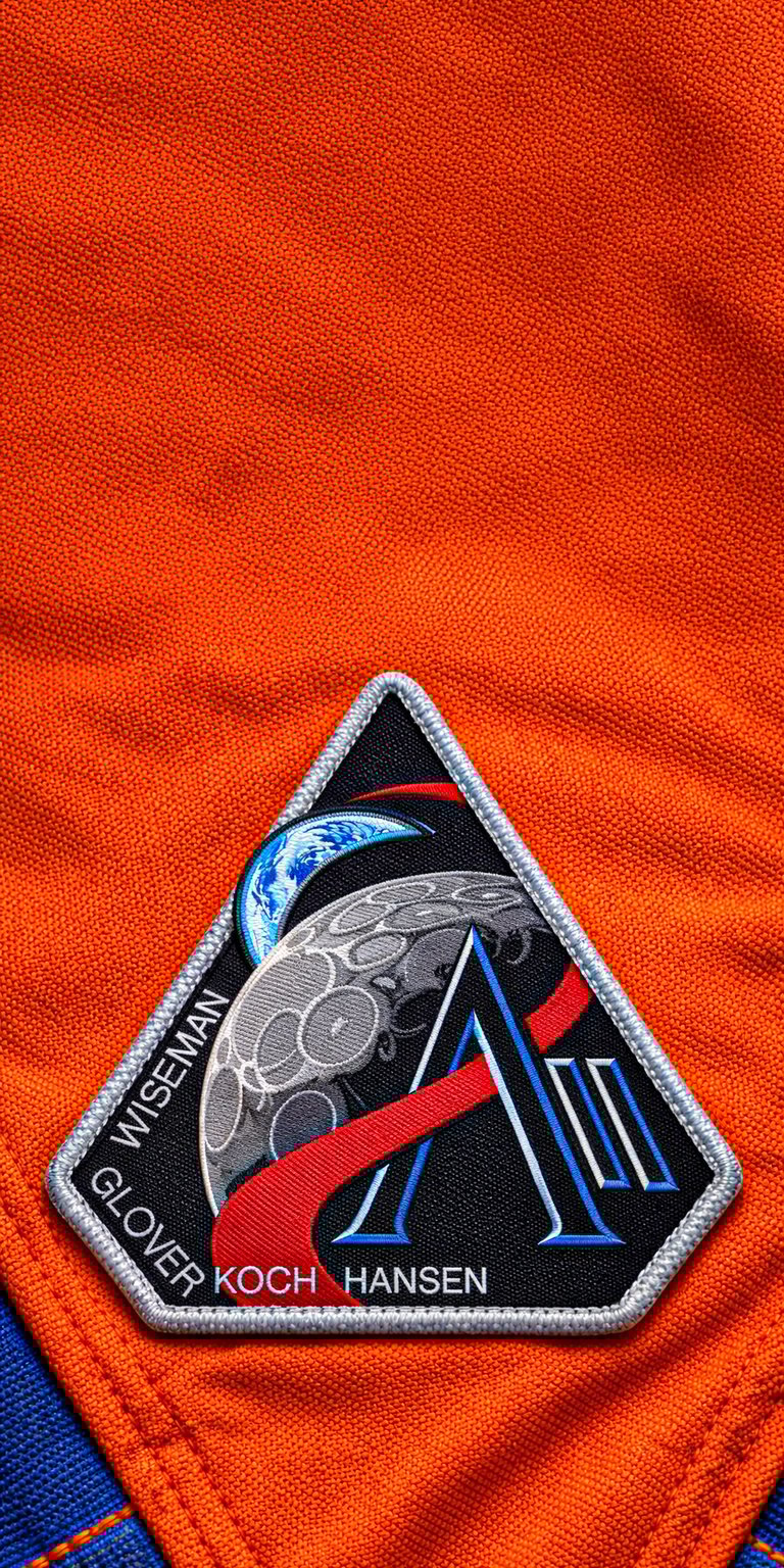 Celebrate lunar exploration with this official Artemis II mission patch wallpaper for your mobile device. This 4K wallpaper highlights intricate embroidered textures and bold NASA branding for a cinematic space-themed lock screen.