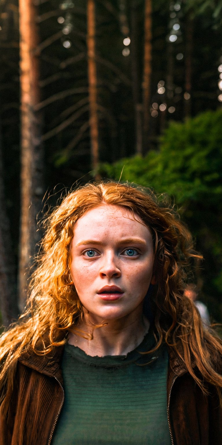 Download this beautiful Sadie Sink 4K wallpaper for your iPhone, showcasing her piercing blue eyes and striking auburn hair against a blurred forest backdrop. This stunning wallpaper captures her expressive face and the natural textures of her corduroy jacket.