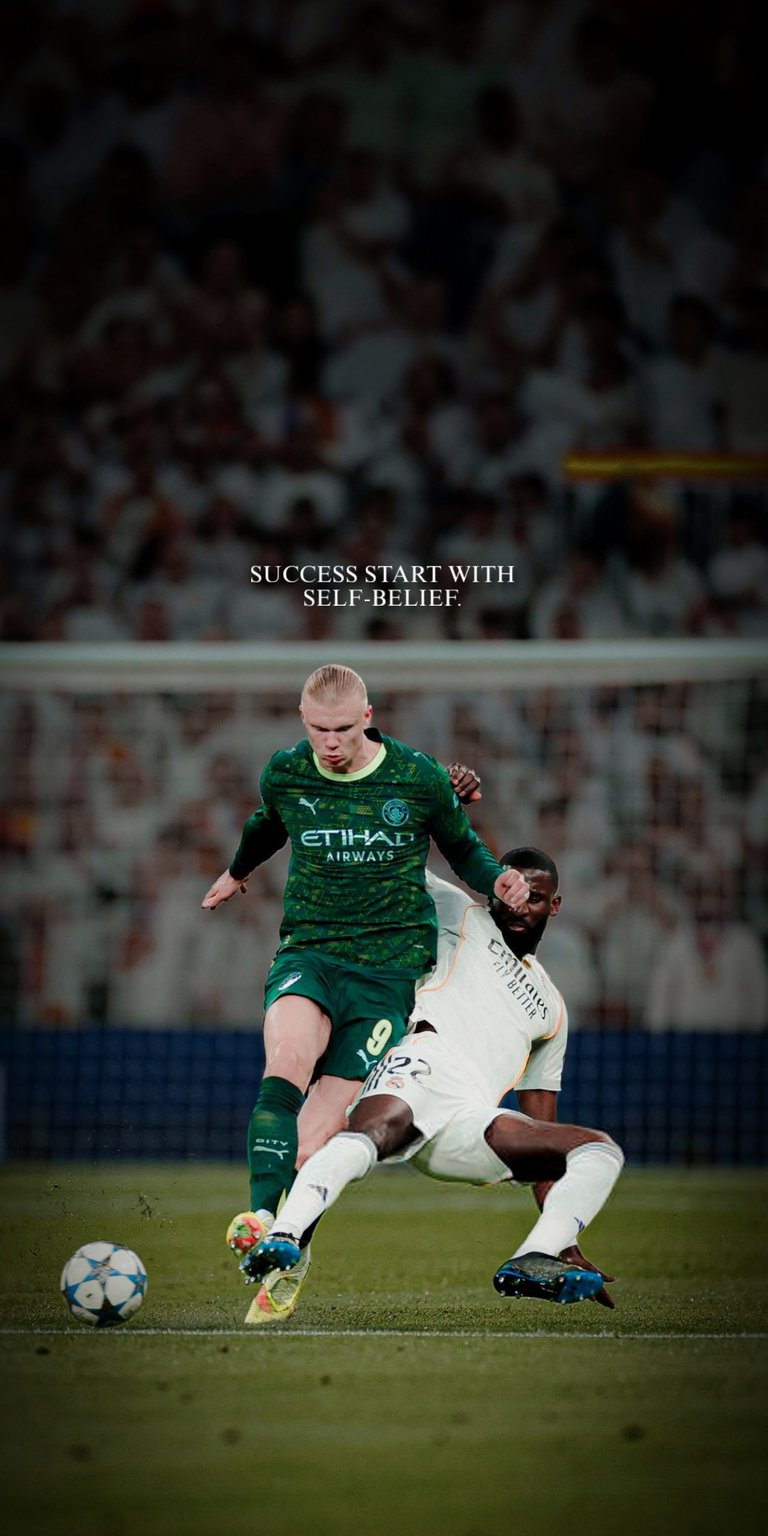 An explosive 4K wallpaper capturing the fierce midfield clash between Manchester City's striker Erling Haaland and Real Madrid's defender Antonio Rüdiger during a Champions League match. The motivational message "SUCCESS START WITH SELF-BELIEF" is perfectly overlaid, making this image ideal for fans who seek high-octane action combined with inspiration. This dynamic, stadium-lit scene is a must-have for showcasing the intensity of elite football on your device.