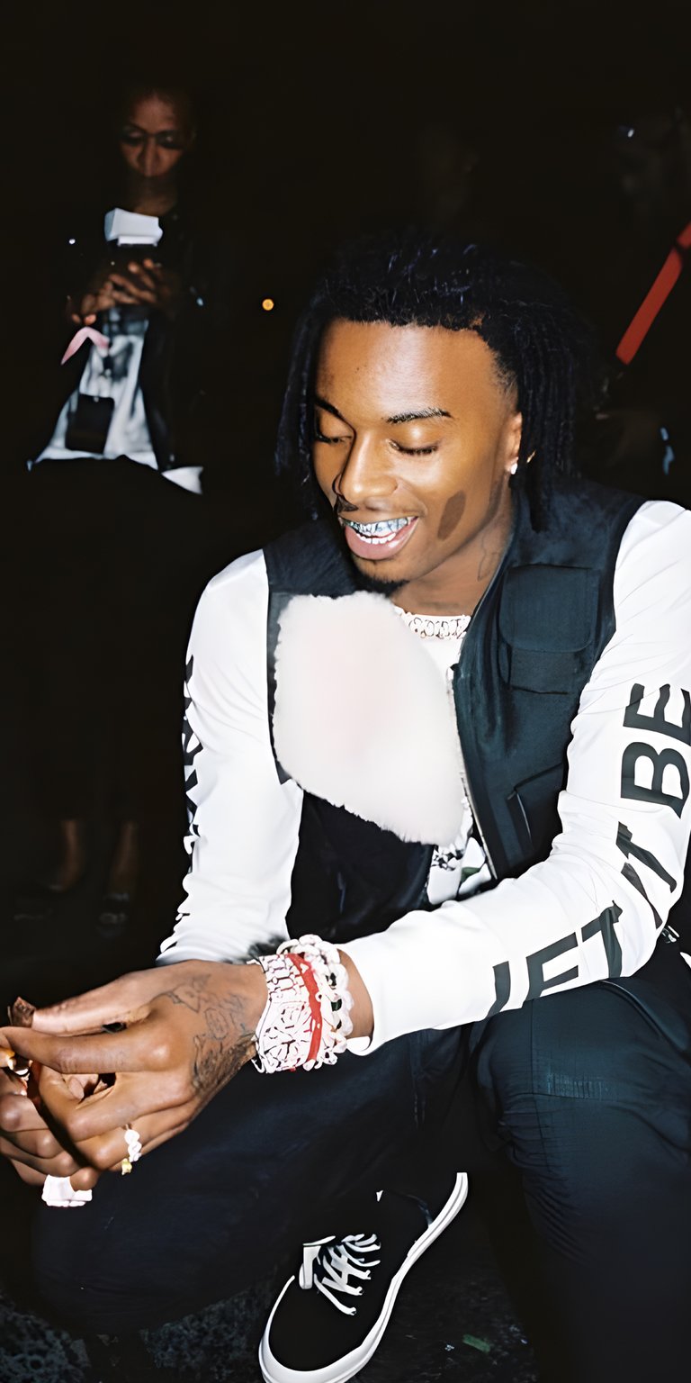 Carti sitting wearing white long sleeves  smiling wallpaper