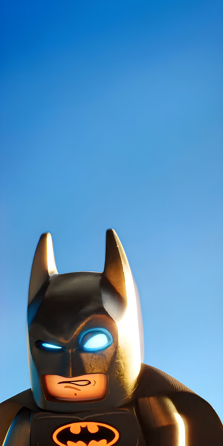 Download this 4K Lego Batman wallpaper for your iPhone, showcasing his iconic glowing blue eyes. Against a stark blue sky, this wallpaper highlights the Lego figure's orange logo.