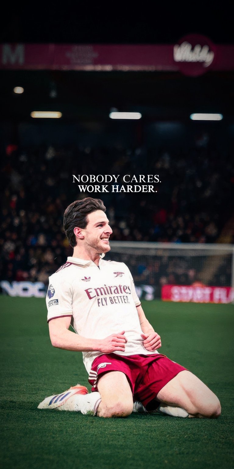 Arsenal’s Declan Rice is shown in a gritty, action-oriented pose on the pitch, wearing the classic red and white Gunners kit. The overlay reads: "NOBODY CARES. WORK HARDER." This wallpaper is designed for those who value the "grind" and the silent work put in behind the scenes, featuring high-grain textures and professional sports photography.