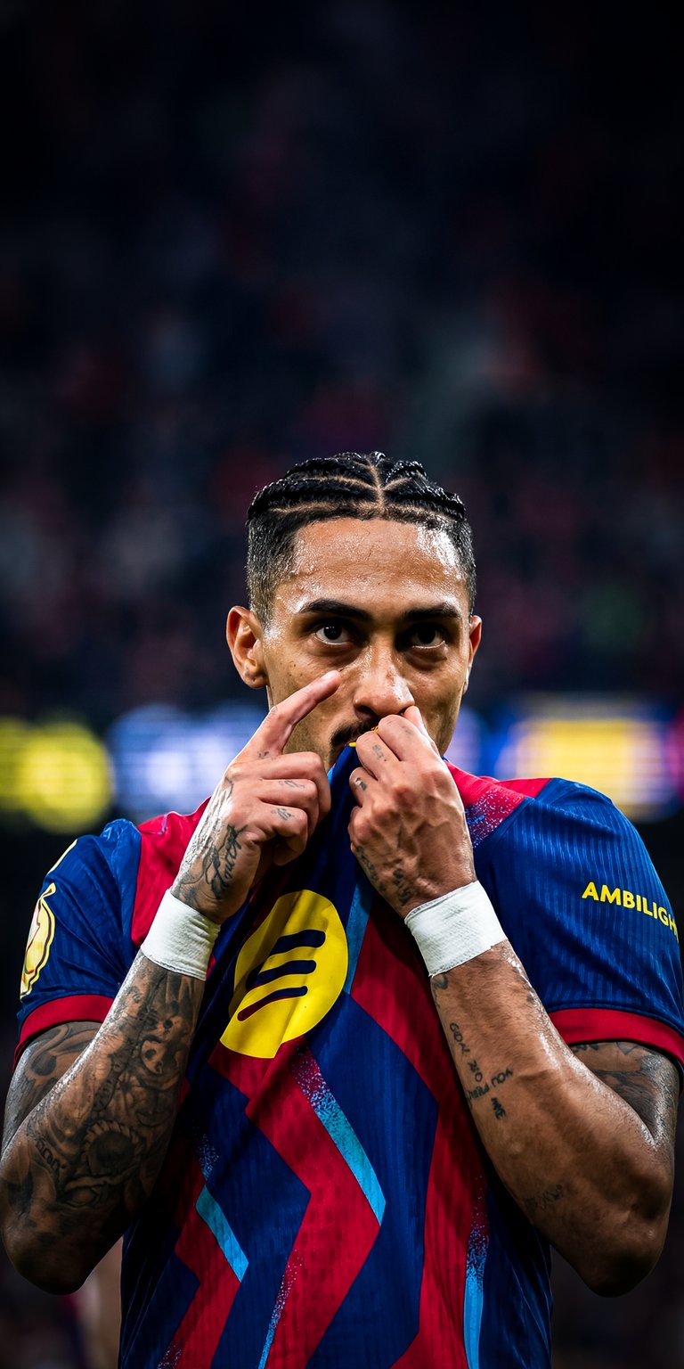 Get this awesome Raphinha 4K wallpaper for your iPhone, showcasing the FC Barcelona player's unique braids and arm tattoos. This wallpaper captures Raphinha in action with his hand near his mouth, giving your device a dynamic look.