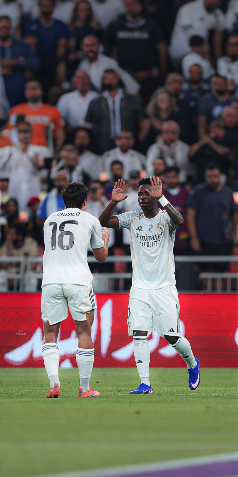 Get this Vinicius Jr 4K wallpaper for your iPhone, showcasing the soccer player high-fiving a teammate while sporting vibrant blue cleats. This stunning wallpaper captures the energy of the game.