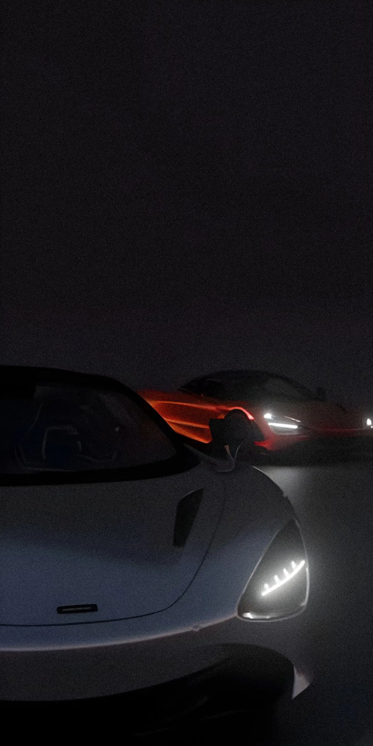 Experience the thrill of the race with this Mclaren 4K wallpaper for your iPhone. The headlights illuminate the sleek design and the orange accents glow against the dark backdrop, making this wallpaper a must-have.